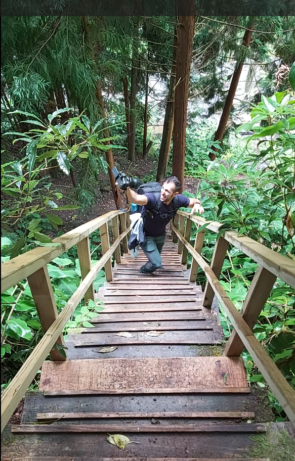 Juan López vlogueando con su cámara en unas escaleras de madera en Azores